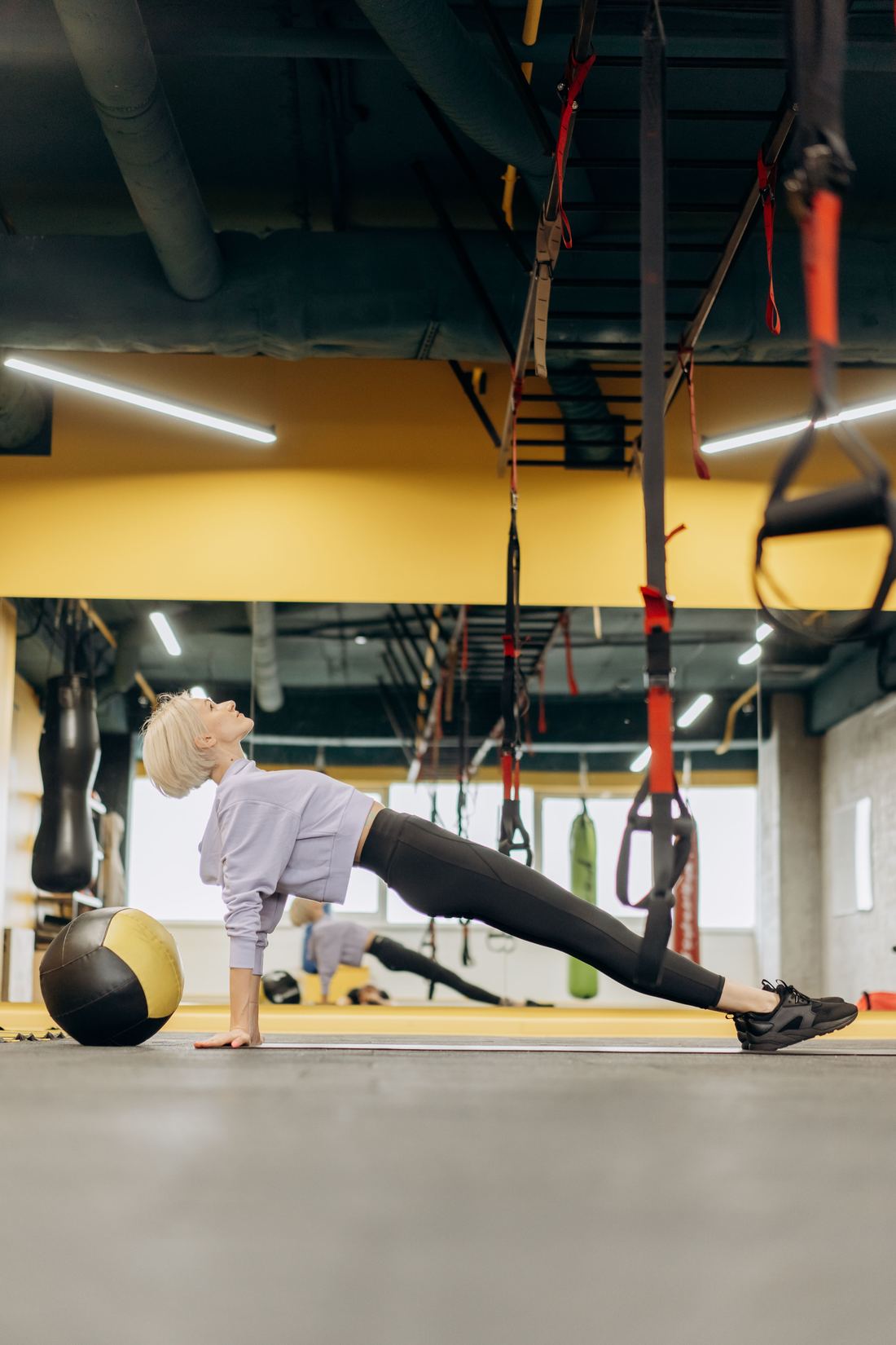 Woman training with suspension straps in a gym